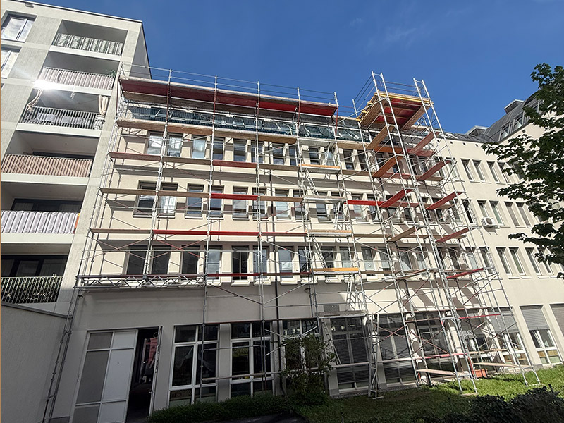 Lastturm mit Ausschussgerüst bei einem Mehrparteienhaus in Innsbruck, aufgebaut von Gerüstbau Mair