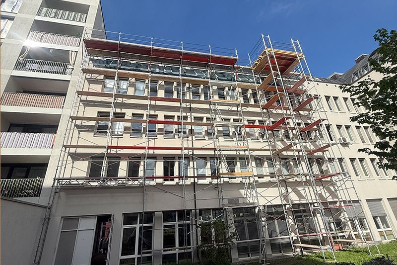 Lastturm mit Ausschussgerüst bei einem Mehrparteienhaus in Innsbruck, aufgebaut von Gerüstbau Mair